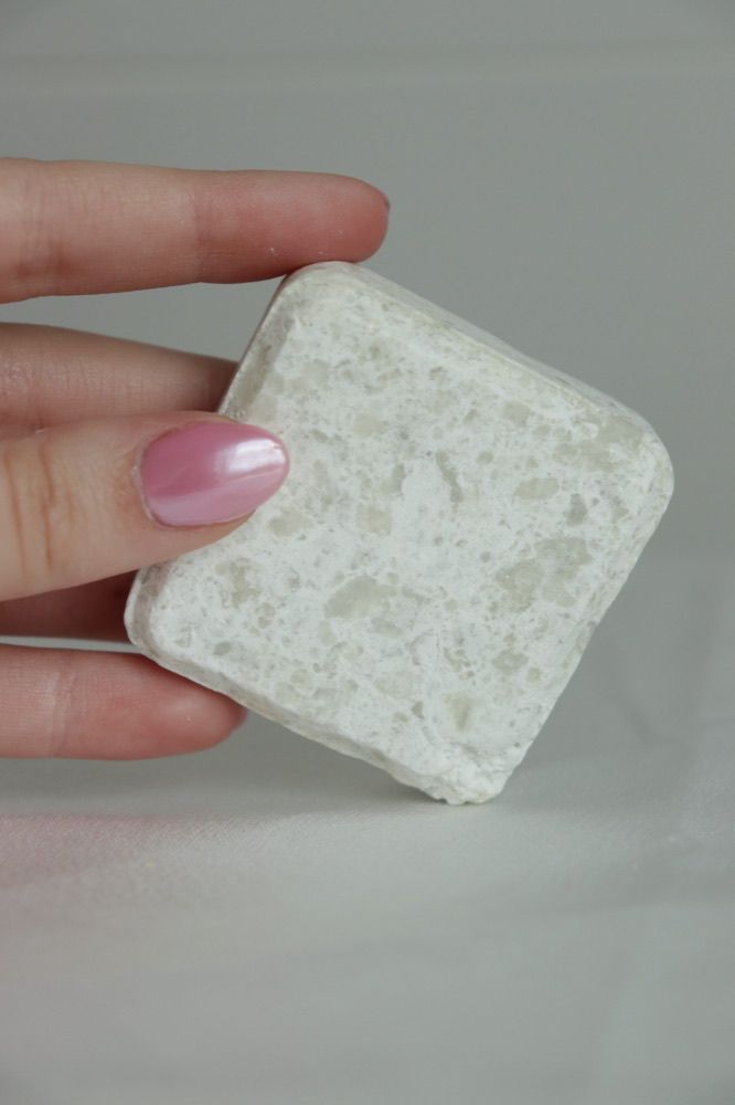 Mano sosteniendo la pastilla del limpiador facial sólido Clean Skin de JICALAB