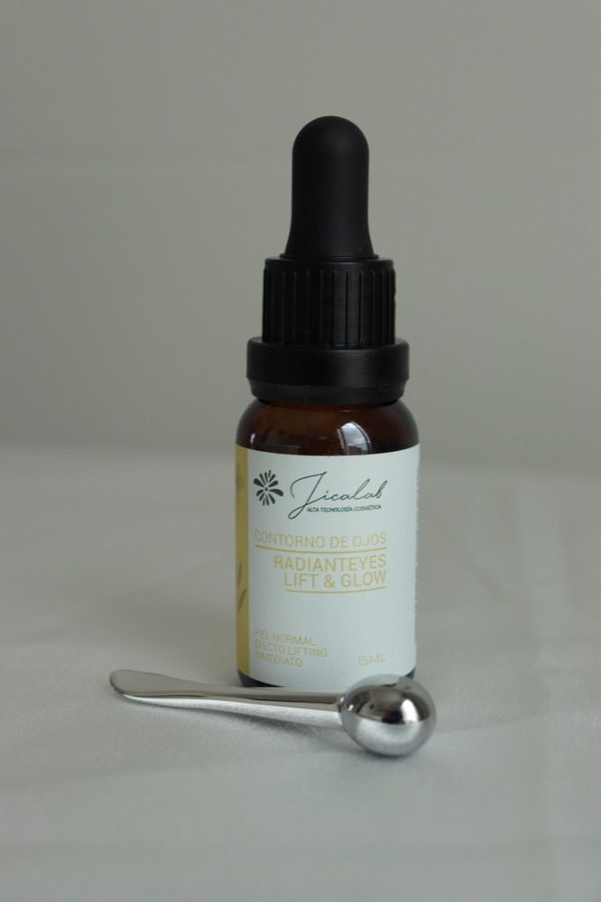 Contorno de ojos RadiantEyes Lift & Glow de JICALAB junto a una pequeña espátula metálica